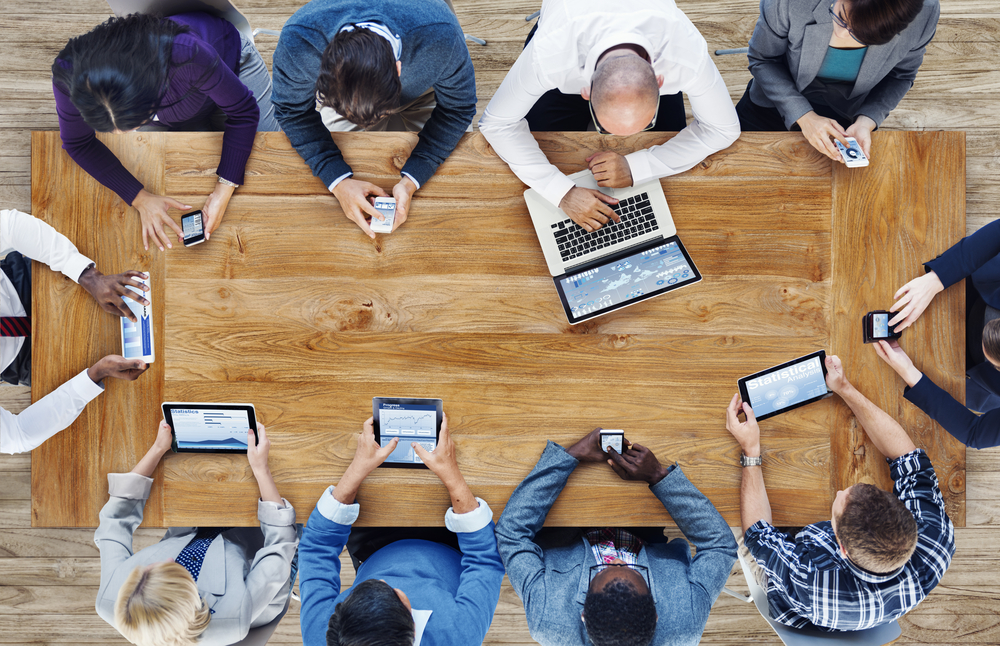 group of people going over the mobile device investment