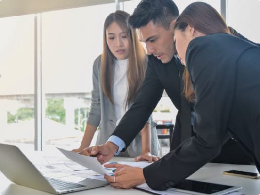 three business partners going over documents on desk