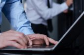 close-up of gentleman typing on laptop