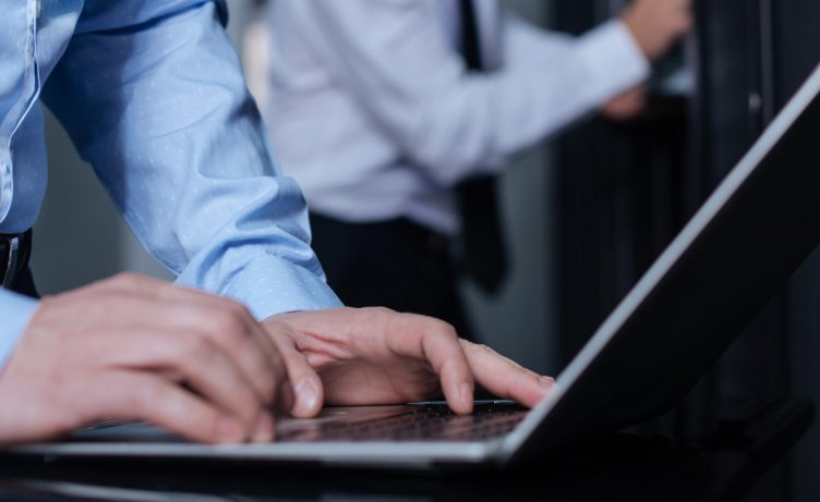 close-up of gentleman typing on laptop