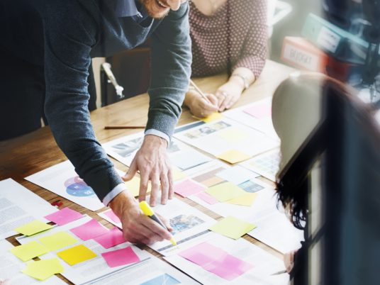 business man highlighting information on document in meeting