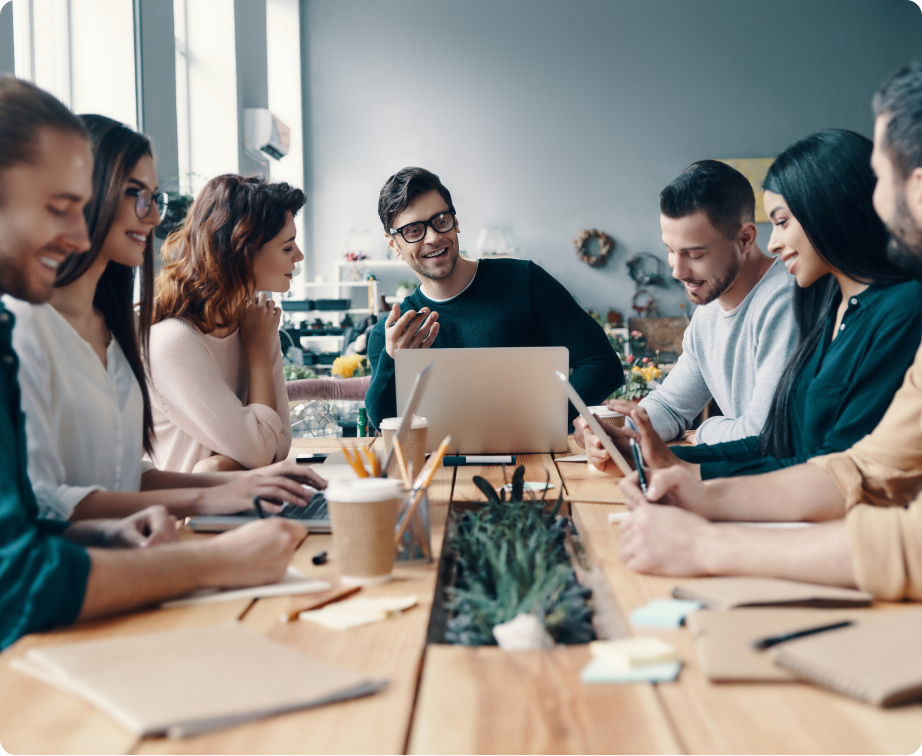 group of coworkers sitting at table smiling and laughing.