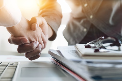 businesswoman and businessman shaking hands