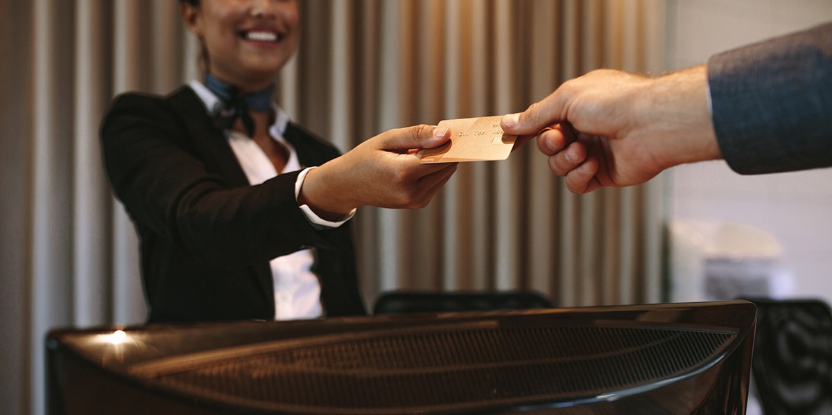 handing lady a credit card at a hotel