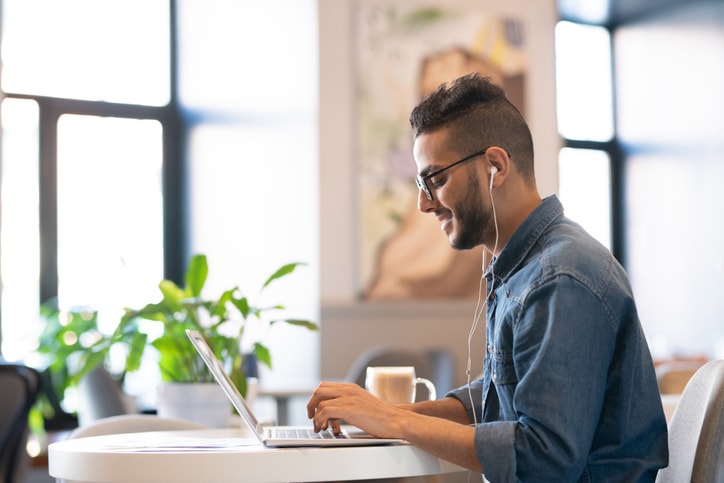 gentleman wearing headphones and typing on computer