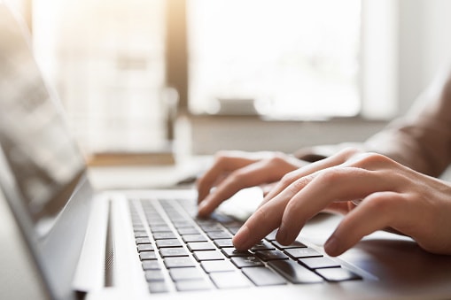 close-up of a woman typing on keyboard