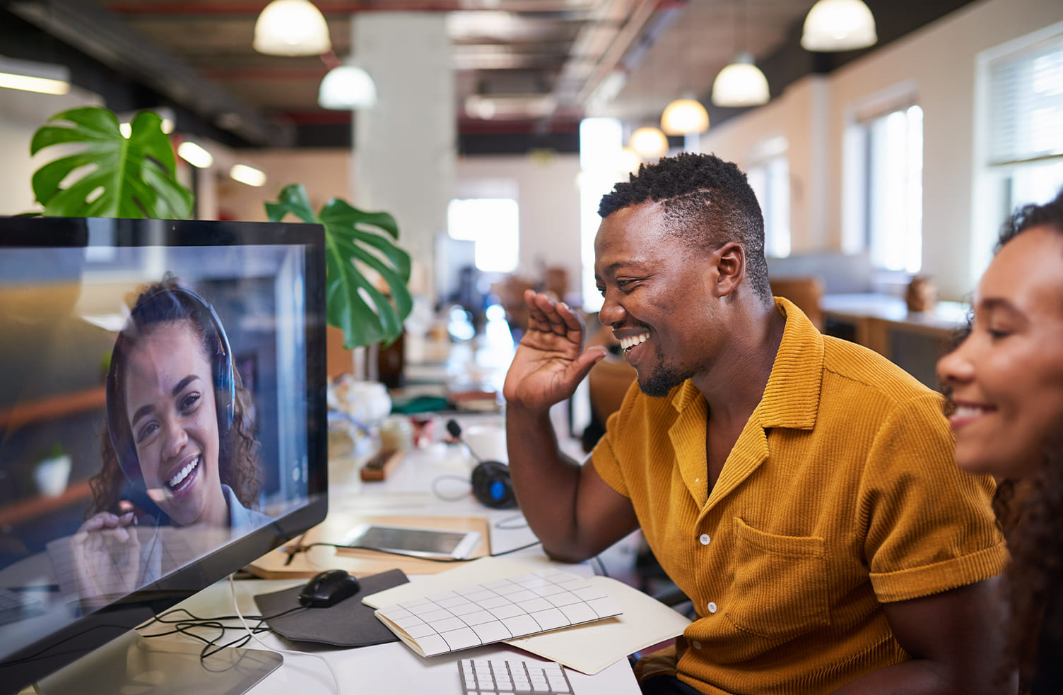 man waving to coworker on a video call